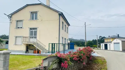 a white house with flowers in front of it at Carballeira house in Lago