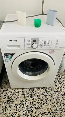 a white washing machine with a green ball on top at Carballeira house in Lago