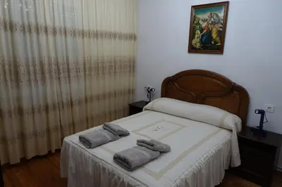 a bedroom with a bed with towels on it at Carballeira house in Lago