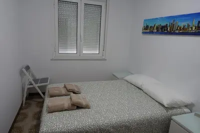 a bed in a white room with a window at Carballeira house in Lago