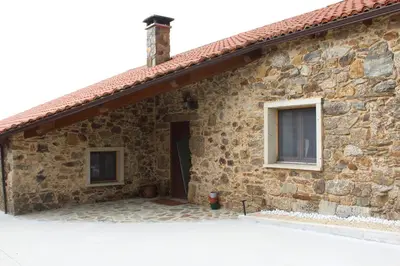 a stone house with a window and a door at CASA PEINADO in Boimorto