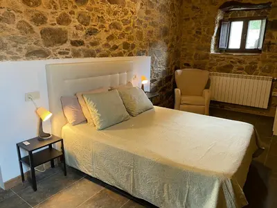 a bedroom with a bed and a table with a lamp at CASA PEINADO in Boimorto