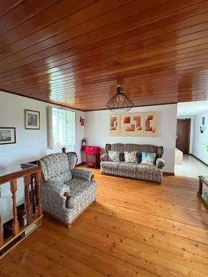 a living room with two couches and a wooden ceiling at A casa do Rio - The River House in Arzúa