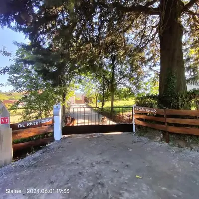 a gate with a tree and a fence at A casa do Rio - The River House in Arzúa