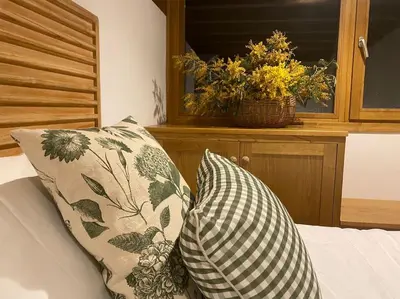 a bed with two pillows and a basket of flowers at A Casa Dos Ratos in Quiroga