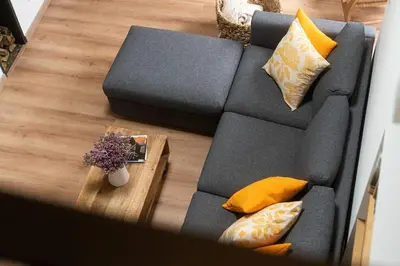 a gray couch with yellow pillows and a table at A Casa Dos Ratos in Quiroga