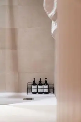 three bottles on a shelf in a bathroom at A Casa Dos Ratos in Quiroga