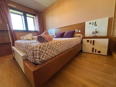 a bedroom with a large bed with purple pillows at Refuxio Xacobeo - Apartamento céntrico en Sarria in Sarria