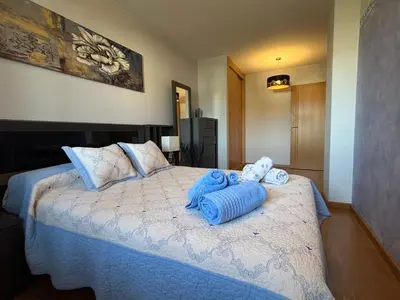 a bedroom with a large bed with towels on it at Refuxio Xacobeo - Apartamento céntrico en Sarria in Sarria