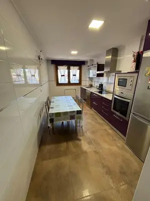 a kitchen with a table in the middle of it at Refuxio Xacobeo - Apartamento céntrico en Sarria in Sarria