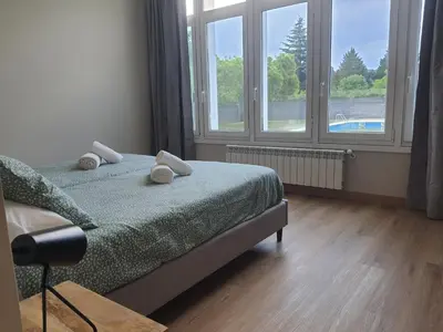 a bedroom with a bed and two windows at Pensión CREDENCIAL in Sarria