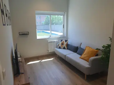a living room with a couch and a window at Pensión CREDENCIAL in Sarria