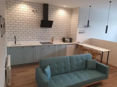 a living room with a blue couch in a kitchen at Pensión CREDENCIAL in Sarria