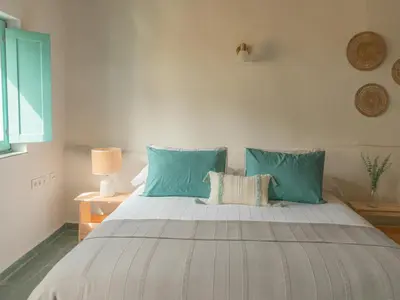 a bedroom with a large bed with blue pillows at Casa Marela in Rinlo
