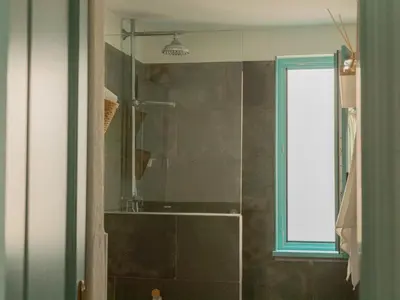 a bathroom with a glass shower with a window at Casa Marela in Rinlo