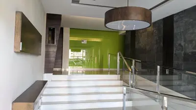 a hallway with a staircase with a green wall at FOZLIDAYS! Apartamento, parking & relax in Foz