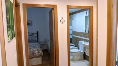 a bathroom with a sink and a toilet and a bed at FOZLIDAYS! Apartamento, parking & relax in Foz