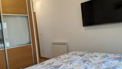 a bedroom with a bed and a flat screen tv at FOZLIDAYS! Apartamento, parking & relax in Foz
