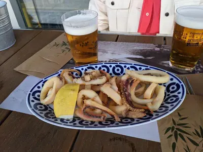 a plate of food and two beers on a table at FOZLIDAYS! Apartamento, parking & relax in Foz