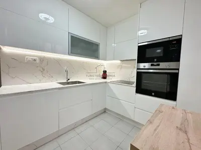 a white kitchen with a sink and a microwave at O Rincón de Laly in Ourense