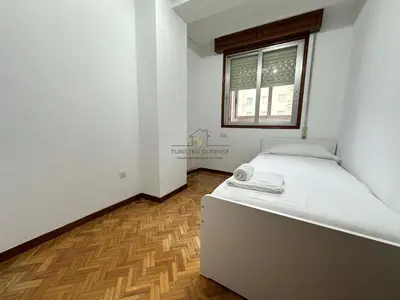a small bedroom with a bed and a window at O Rincón de Laly in Ourense