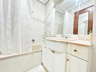 a bathroom with a sink and a tub and a mirror at O Rincón de Laly in Ourense