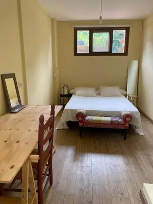 a bedroom with a bed and a wooden table at A casa de Roque 1 in Miño