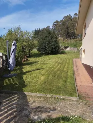 a yard with an umbrella on the side of a house at A casa de Roque 1 in Miño