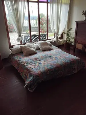a large bed with pillows in a room with windows at A casa de Roque 1 in Miño