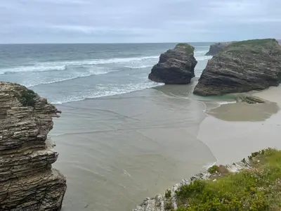 a beach with two large rocks in the ocean at El Puerto in figueras