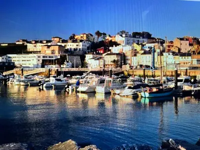 a group of boats docked in a harbor with buildings at El Puerto in figueras
