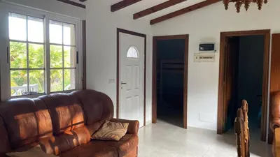 a living room with a brown leather couch and windows at La Fincurri del Nando in A Coruña