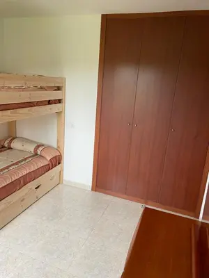 a bedroom with two bunk beds and a wooden cabinet at La Fincurri del Nando in A Coruña
