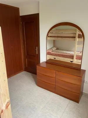 a bedroom with a wooden dresser with a bed in it at La Fincurri del Nando in A Coruña
