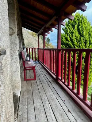 a red bench sitting on a wooden deck at Lagar de Guxeva in Chantada