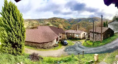 a small village with a car parked in a road at Lagar de Guxeva in Chantada