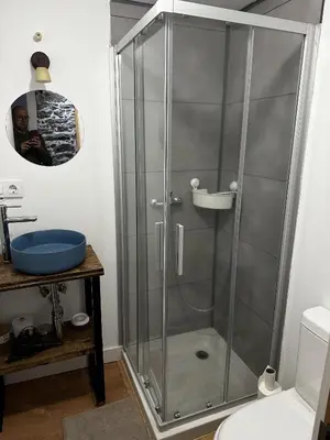 a shower with a glass door in a bathroom at Lagar de Guxeva in Chantada