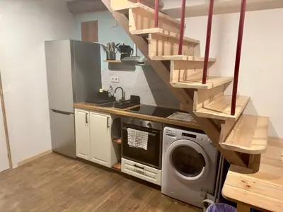 a kitchen with a washing machine and a staircase at Lagar de Guxeva in Chantada