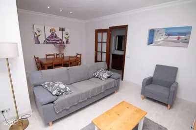 a living room with a gray couch and a chair at CASA Conchita in Ribadeo