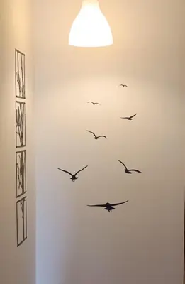 a group of birds flying in a white wall at Piso Dos Playas Miño in Miño