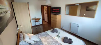 a view of a bedroom with a bed and a mirror at Piso Dos Playas Miño in Miño