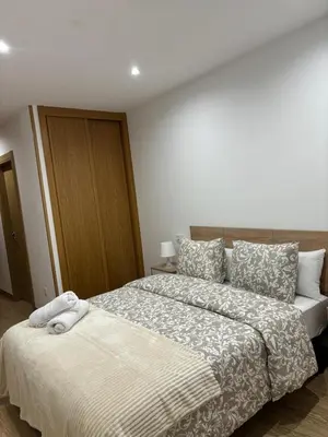 a bedroom with a large bed with a white blanket at Alesamar A in Burela de Cabo