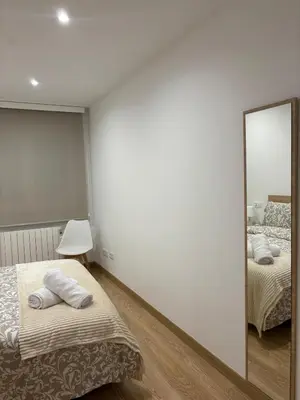 a bedroom with two beds and a mirror at Alesamar A in Burela de Cabo