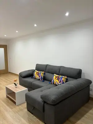 a living room with a gray couch and a table at Alesamar A in Burela de Cabo