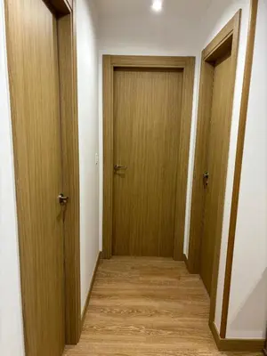 a hallway with two doors and a wooden floor at alesamar B in Burela de Cabo