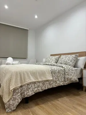 a white bedroom with a large bed and a television at alesamar B in Burela de Cabo