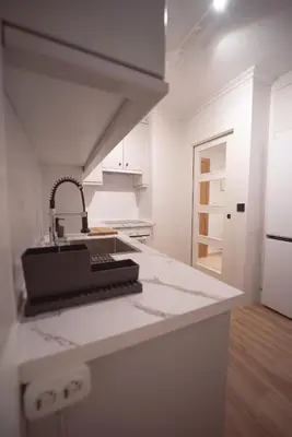 a white kitchen with a sink and a counter top at Apartamento Maremágnum in Viveiro