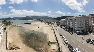 an aerial view of a beach with buildings and cars at Apartamento Maremágnum in Viveiro