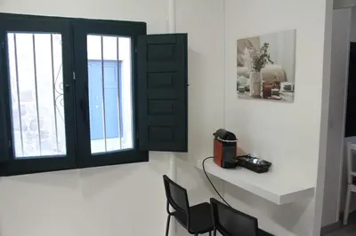 a room with two windows and a table and chairs at Casa dos avós in Ribadavia