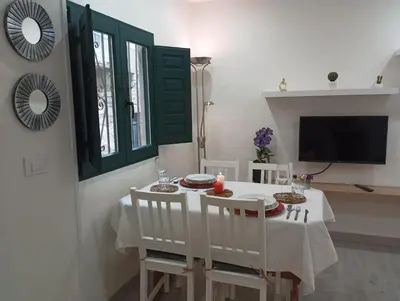 a dining room with a table and chairs and a television at Casa dos avós in Ribadavia